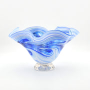 Blue and white glass bowl with wavy design on a white background