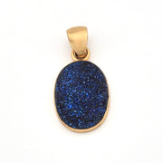 Gold pendant with a blue stone on a white background