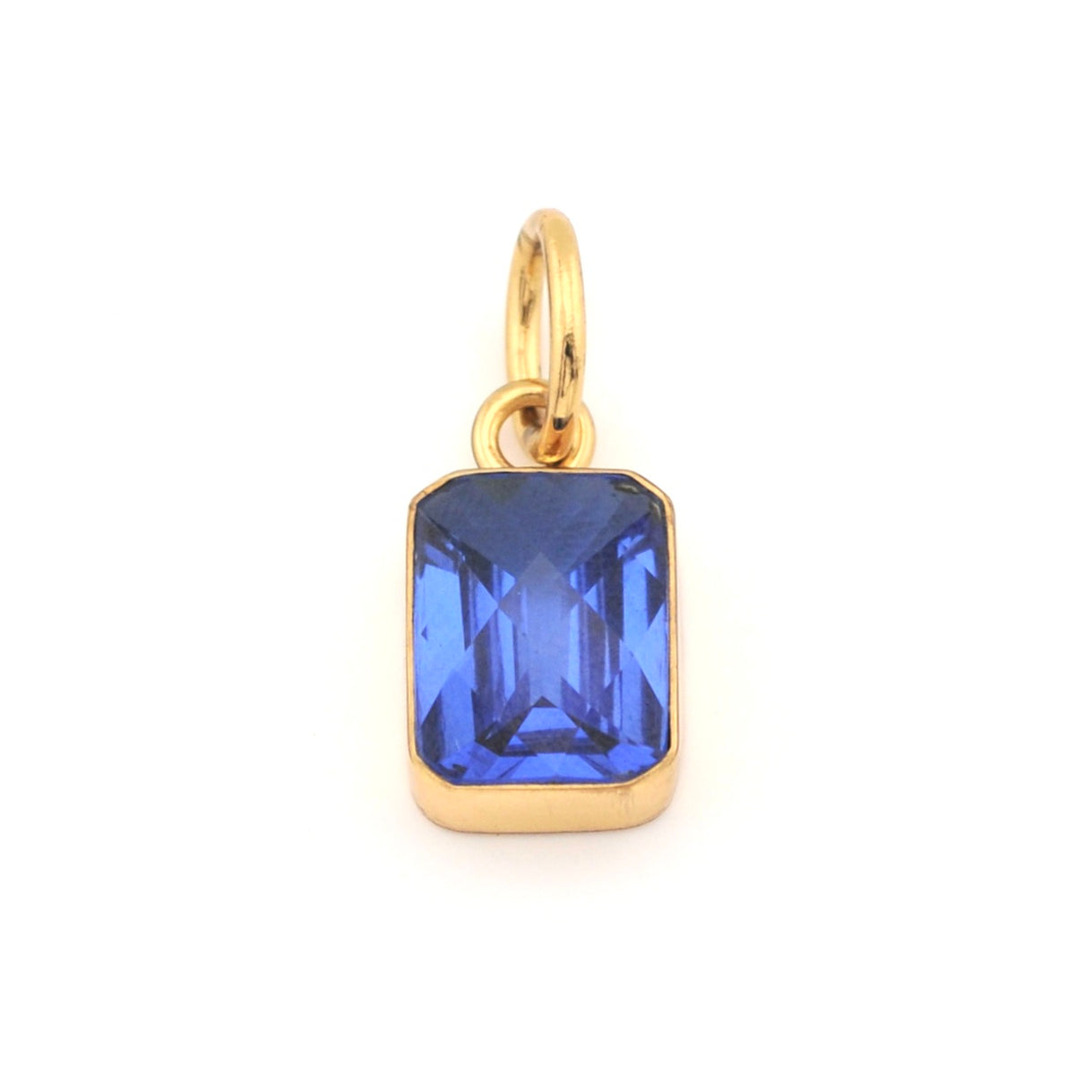 Gold pendant with a blue gemstone on a white background