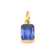 Gold pendant with a blue gemstone on a white background