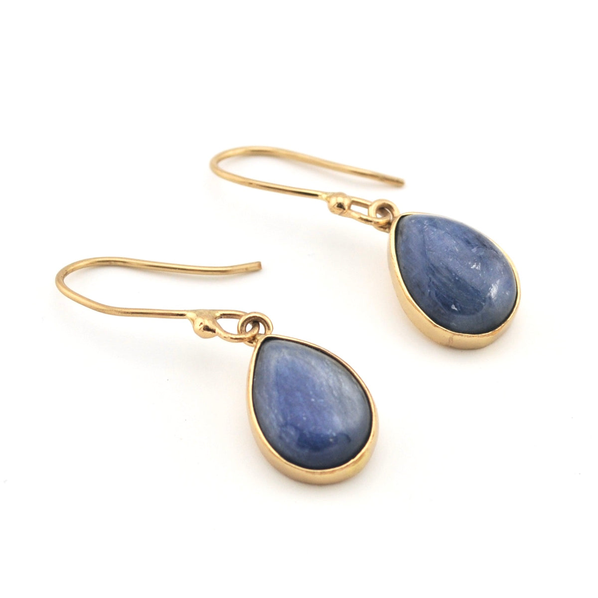 Gold earrings with blue teardrop stones on a white background