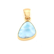 Gold pendant with a blue larimar stone on a white background