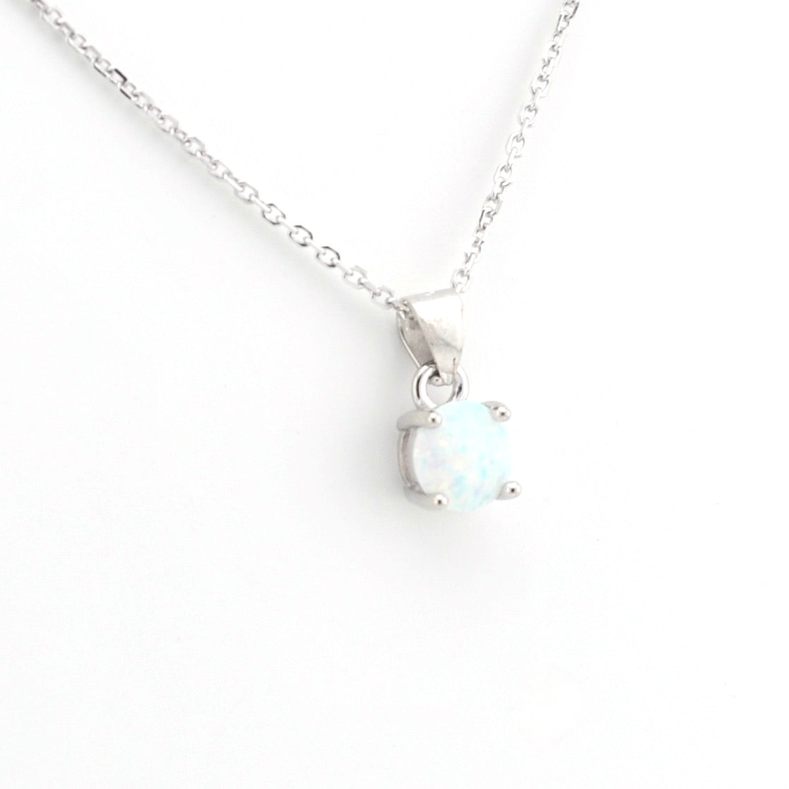 A silver chain necklace with a small oval pendant featuring a white opal-like gemstone in a silver prong setting, shown on a plain white background.