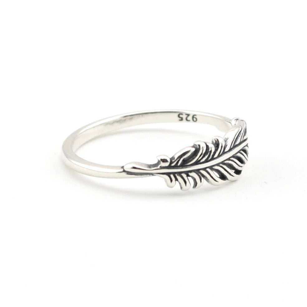 A sterling silver feather ring with a polished band and an intricately detailed feather setting, featuring a '925' hallmark on the inside, shown on a clean white background.