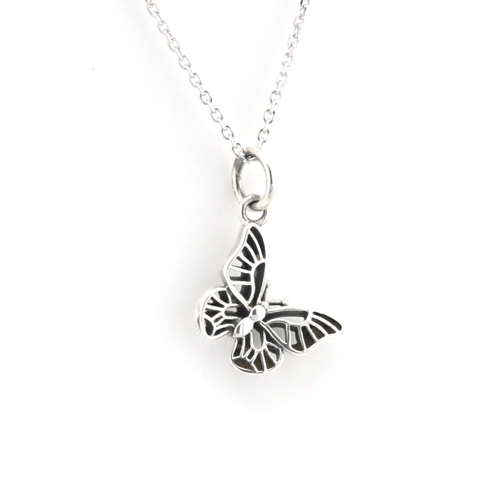 A silver butterfly pendant necklace with an openwork design, hanging from a delicate silver chain against a plain white background.