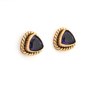 Pair of gold earrings with purple gemstones on a white background