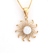 Gold sun-shaped pendant with a white center on a gold chain against a white background