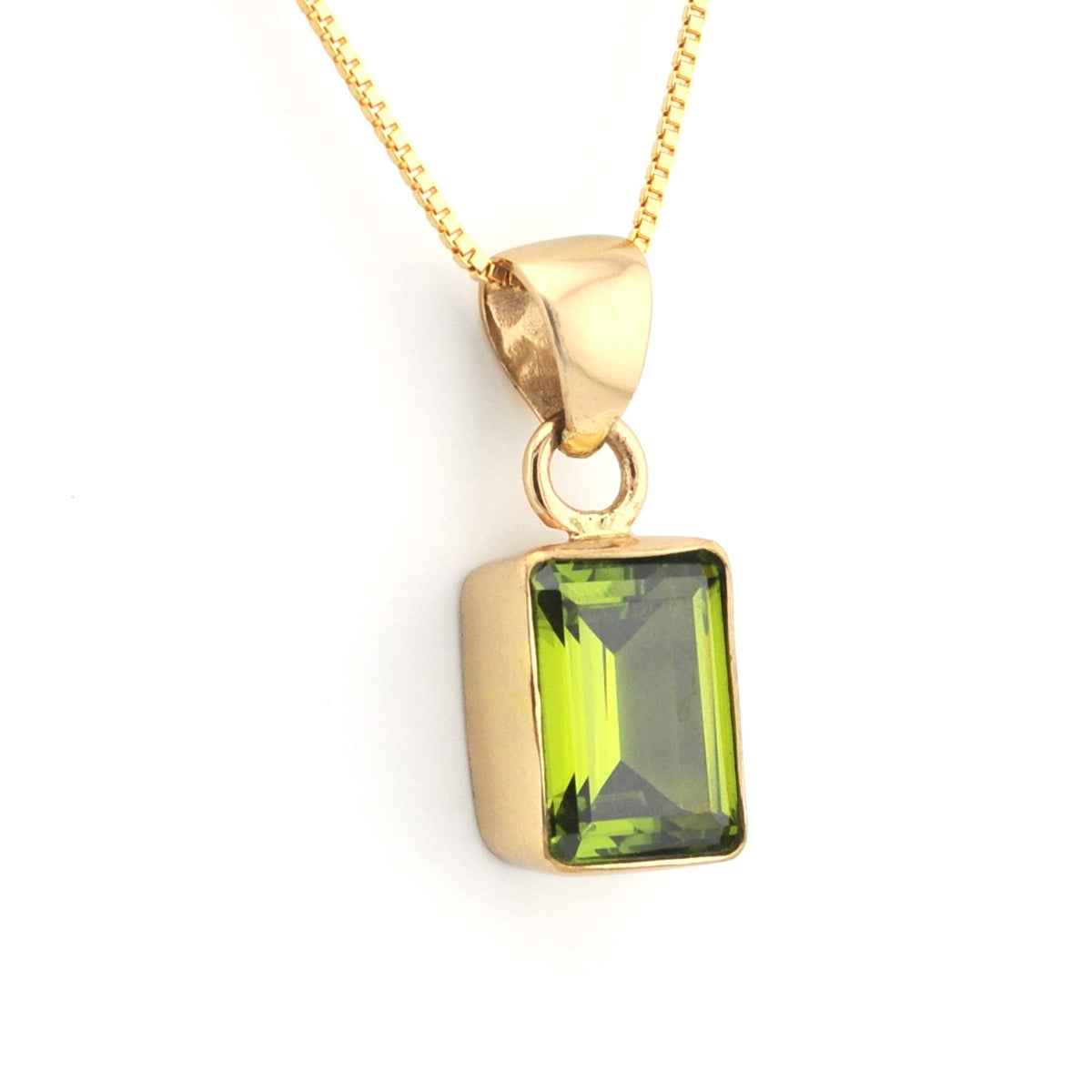 A gold pendant necklace featuring a rectangular green gemstone, shown against a plain white background.