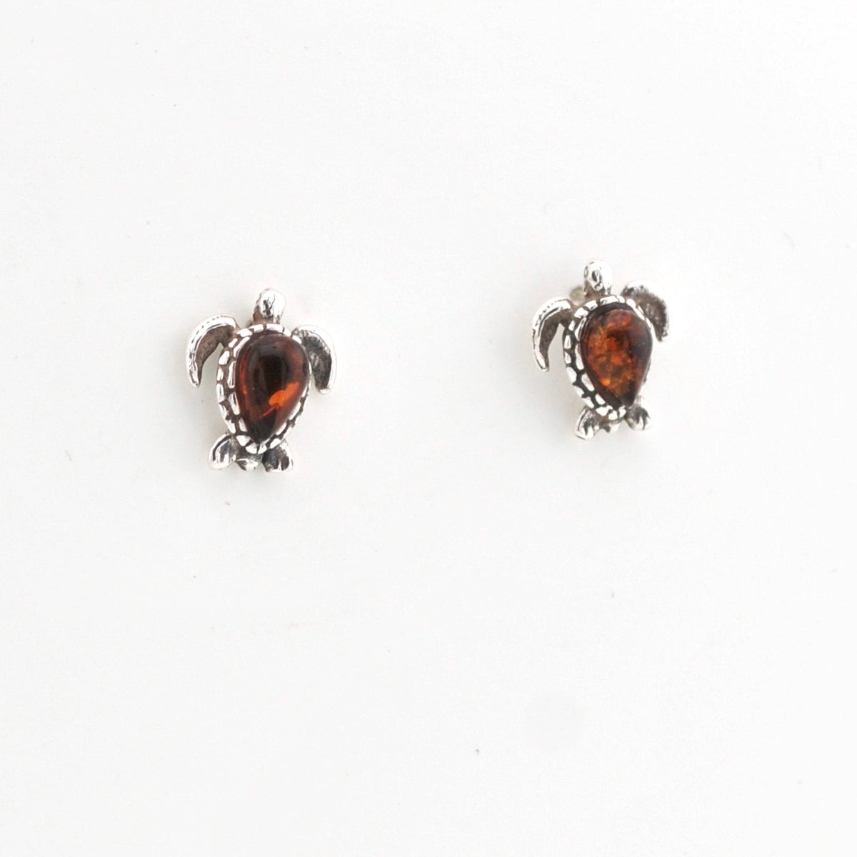 Pair of turtle-shaped earrings with amber stones on a white background