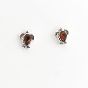 Pair of turtle-shaped earrings with amber stones on a white background
