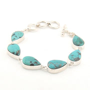 Turquoise teardrop bracelet with silver accents on a white background