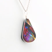 Multicolored teardrop pendant on a silver chain against a white background
