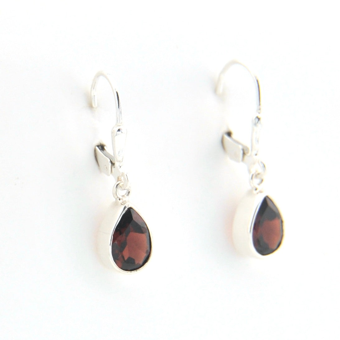 Teardrop-shaped amber earrings on silver hooks against a white background