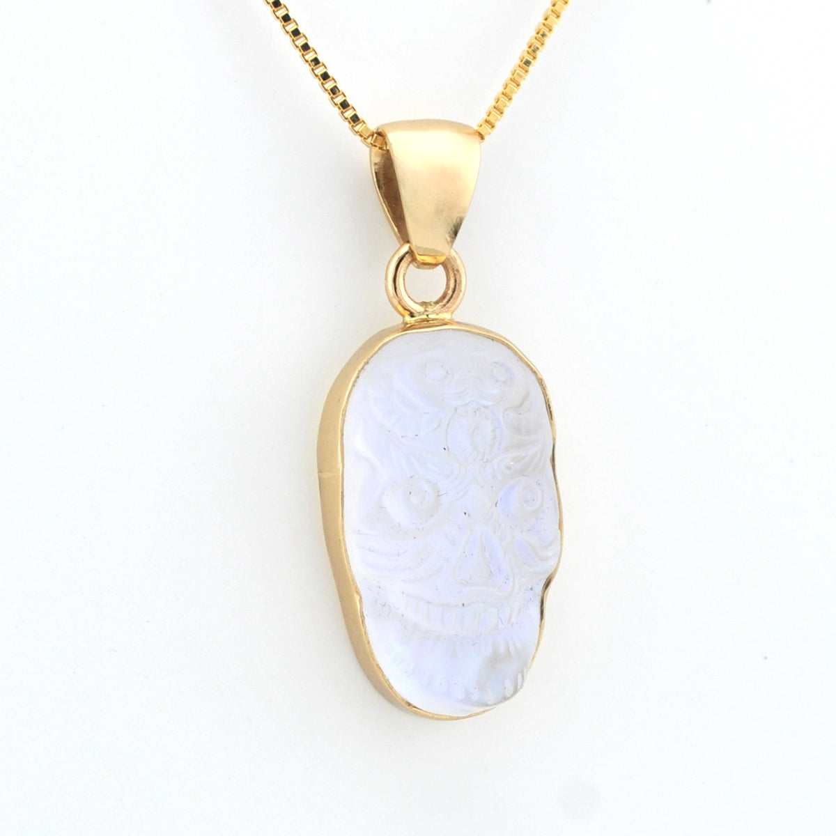 Gold pendant with a white stone on a white background