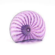 Purple glass sculpture with concentric swirl design on a white background
