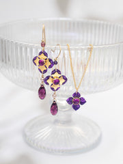 Jewelry set with purple gemstones on a white pedestal