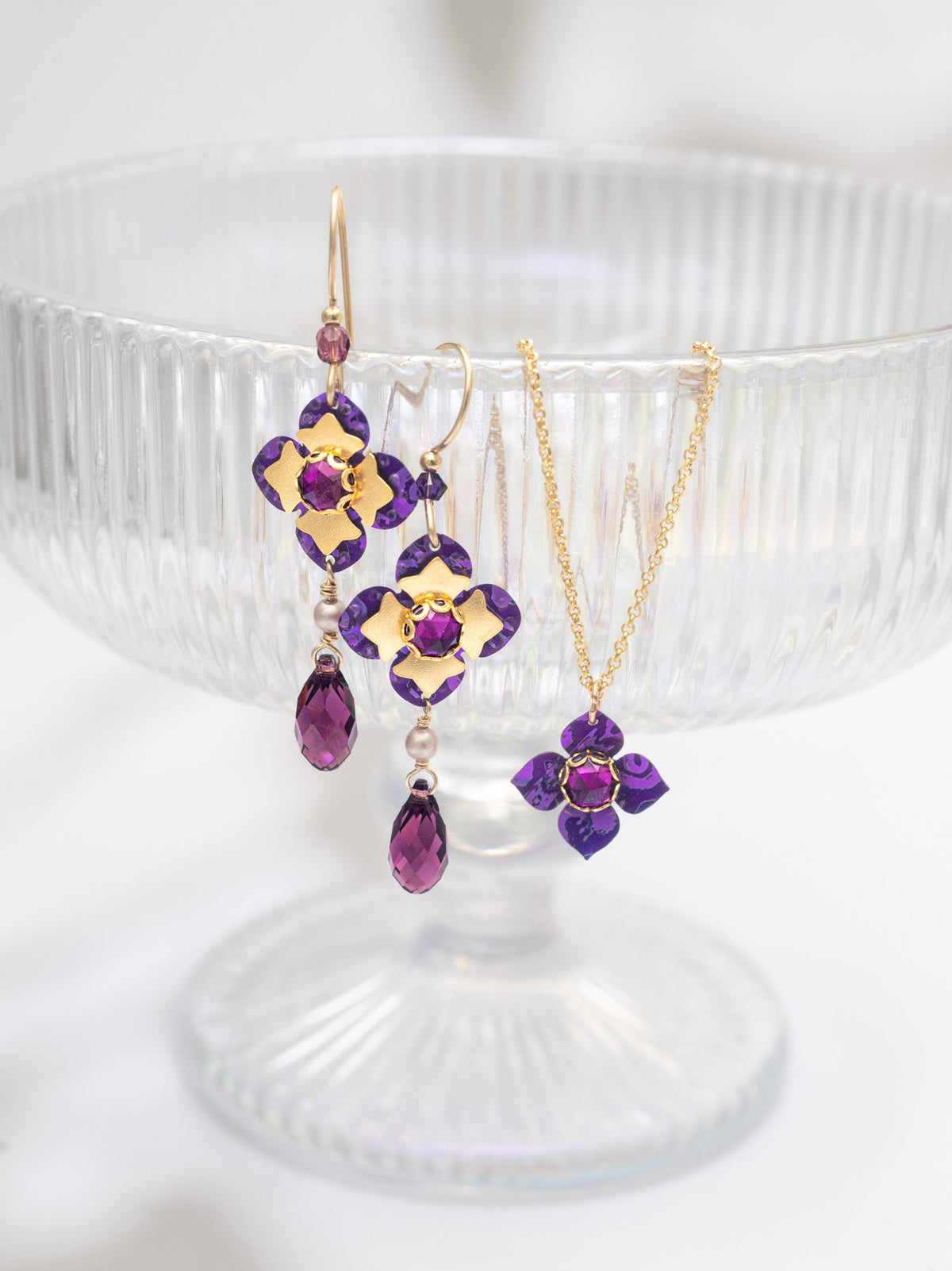 Jewelry set with purple gemstones on a white pedestal