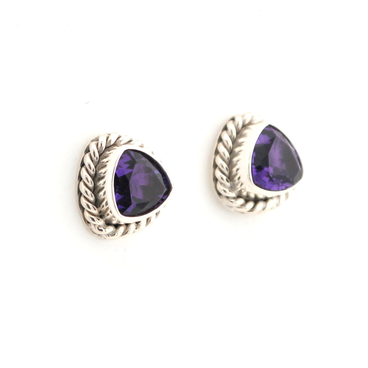 Pair of silver earrings with purple gemstones on a white background