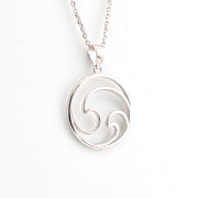 Silver pendant with a wave design on a white background