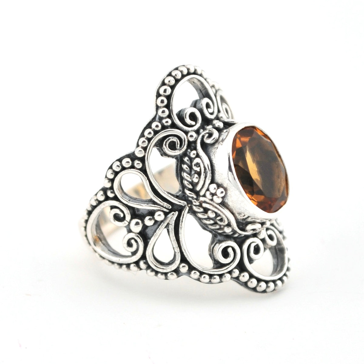 Silver ring with intricate design and a brown gemstone on a white background