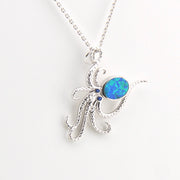 Silver octopus pendant with a blue opal stone on a white background