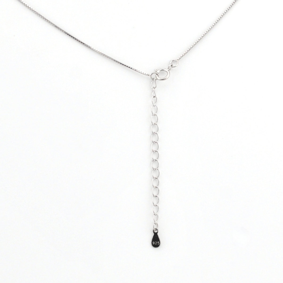 Silver chain necklace with a small black pendant on a white background