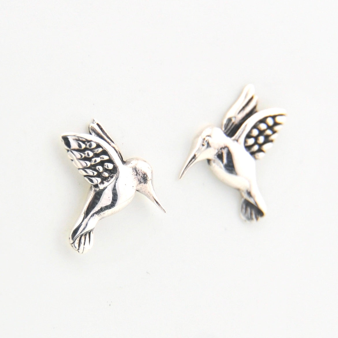 Silver bird-shaped earrings on a white background