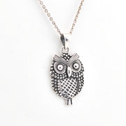 Silver owl pendant necklace on a white background