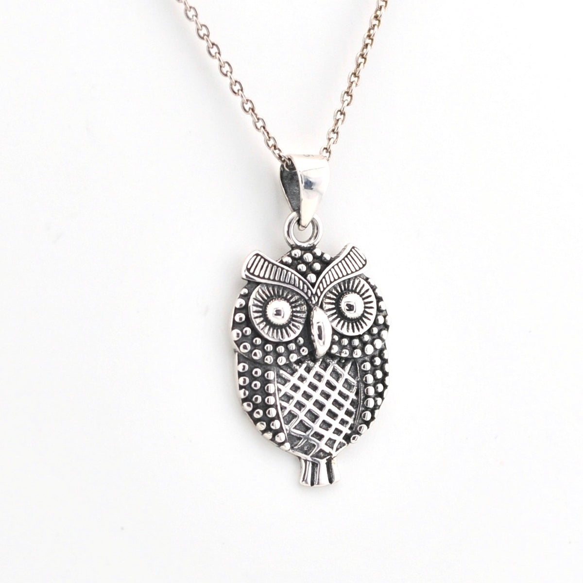 Silver owl pendant necklace on a white background