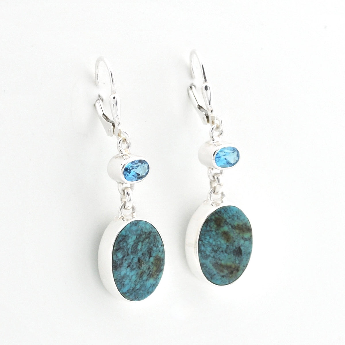Pair of earrings with blue stone drops on a white background