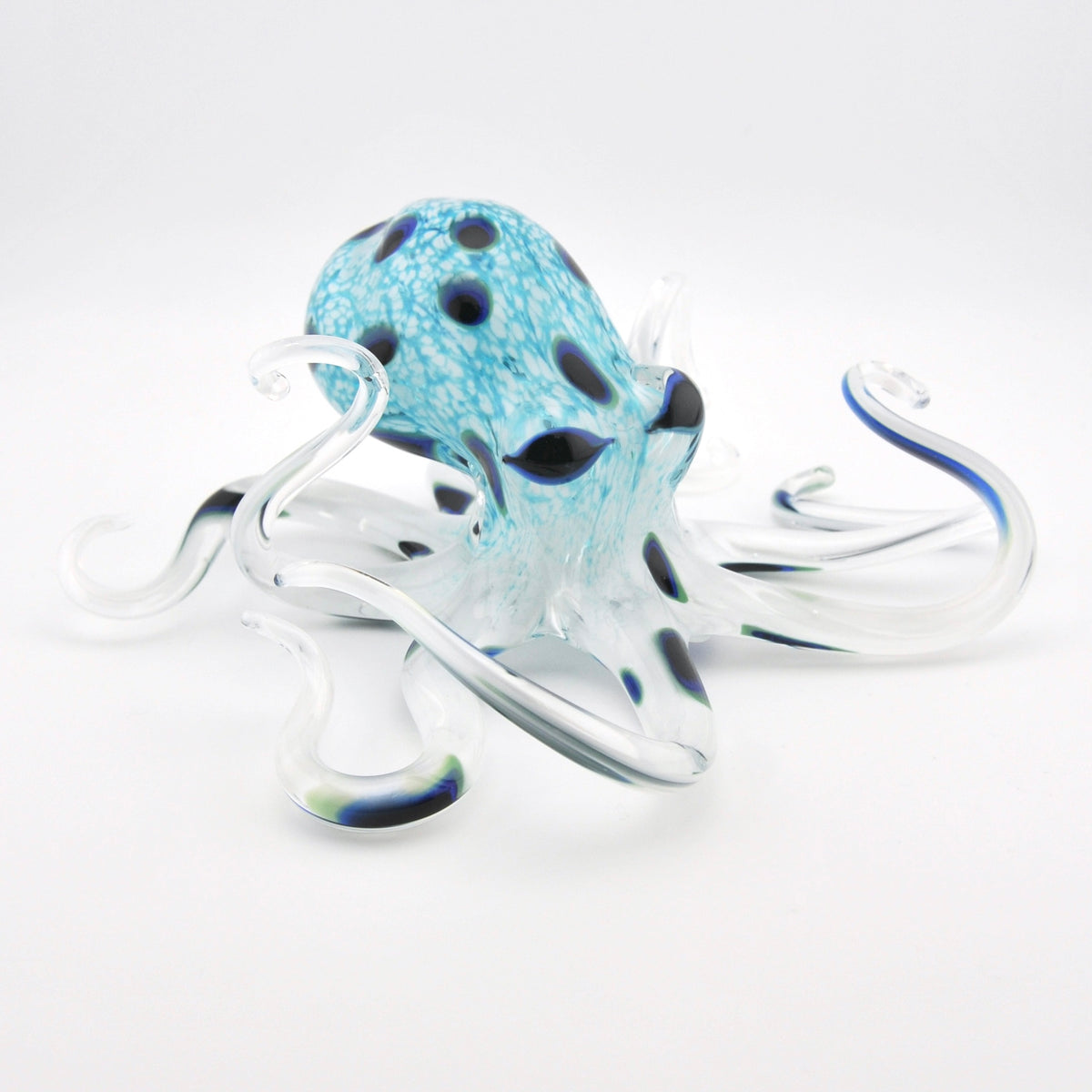 Glass octopus sculpture with blue and white pattern on a white background