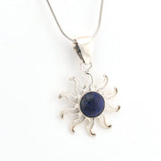 Silver sun-shaped pendant with a blue stone on a white background