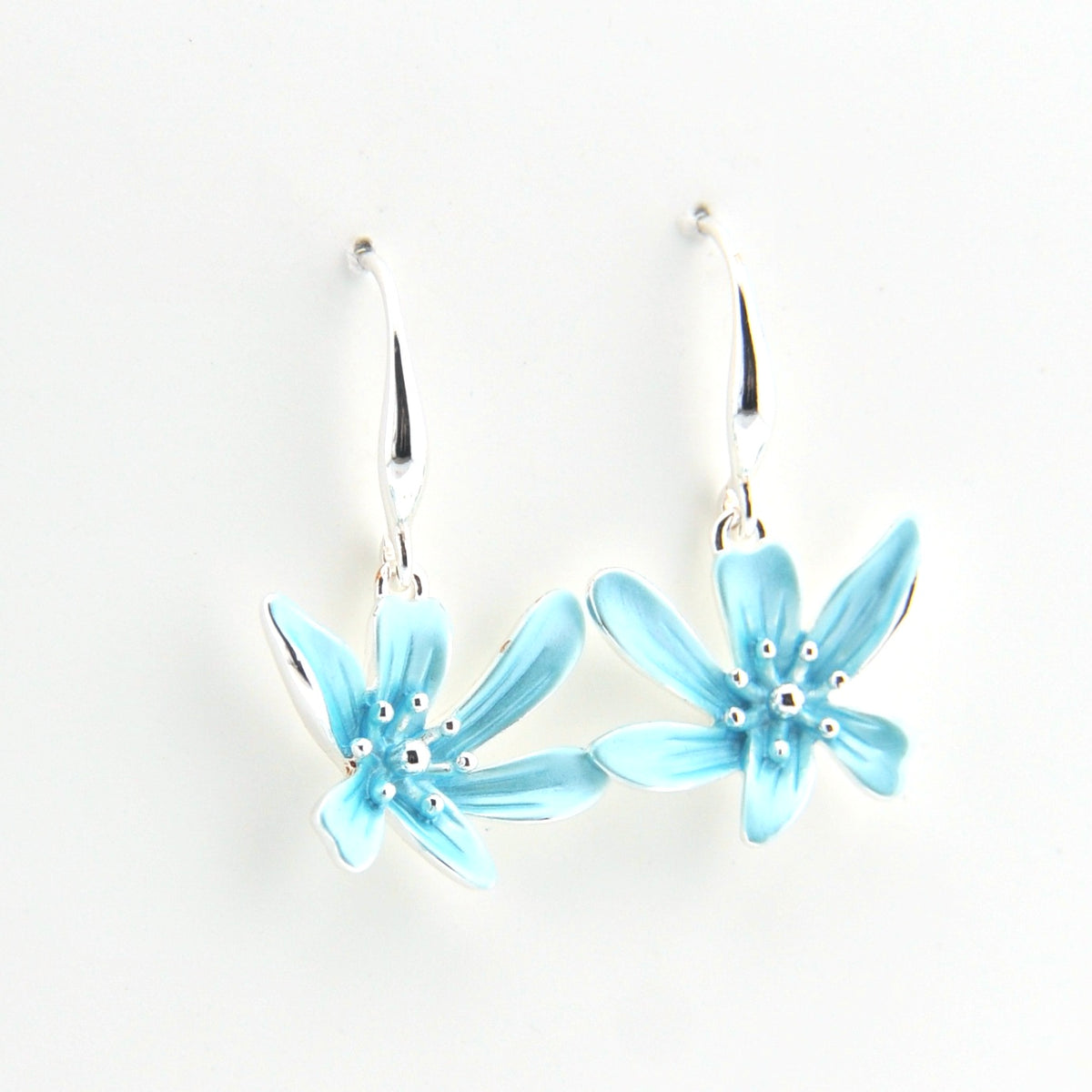 Pair of light blue flower-shaped earrings on a white background