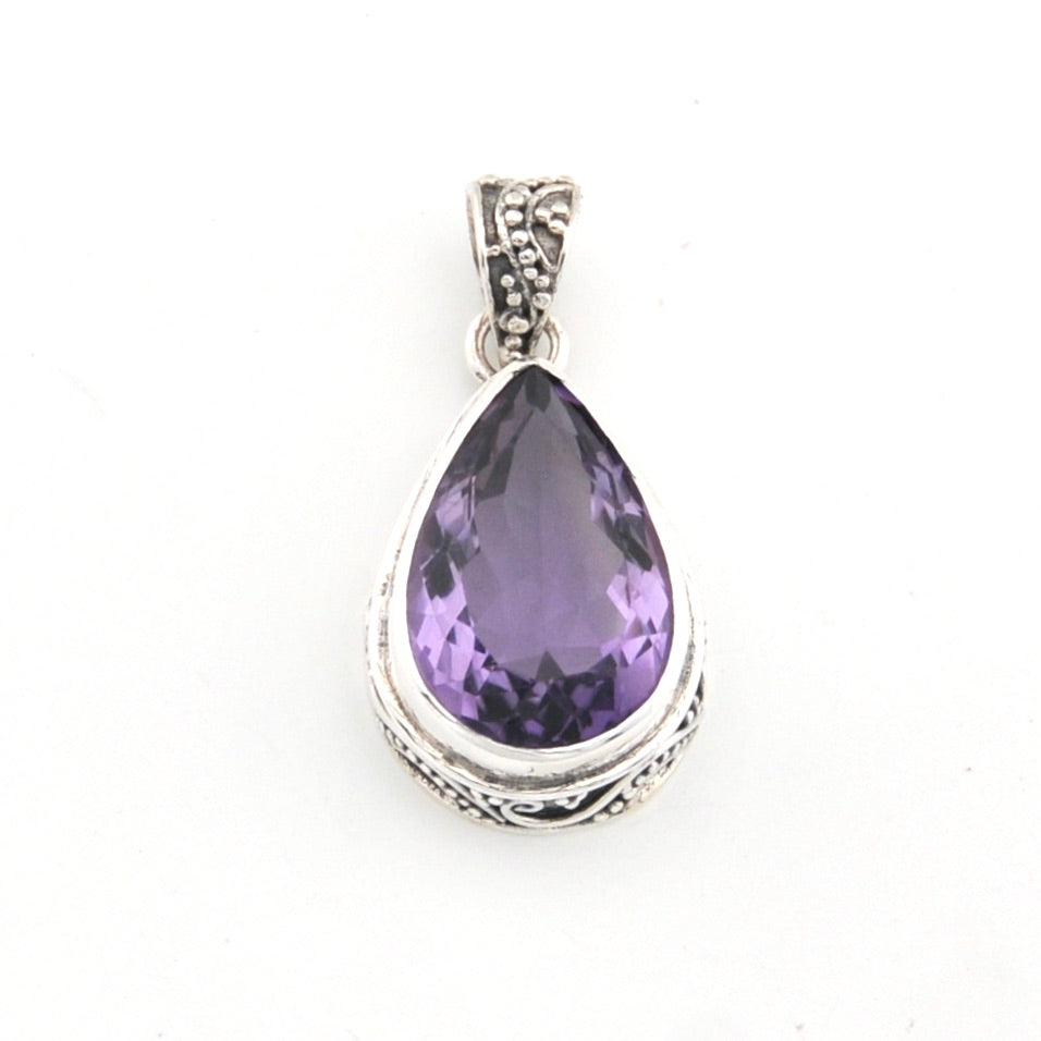 Purple teardrop pendant with silver setting on a white background