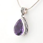 Purple teardrop pendant with silver setting on a white background