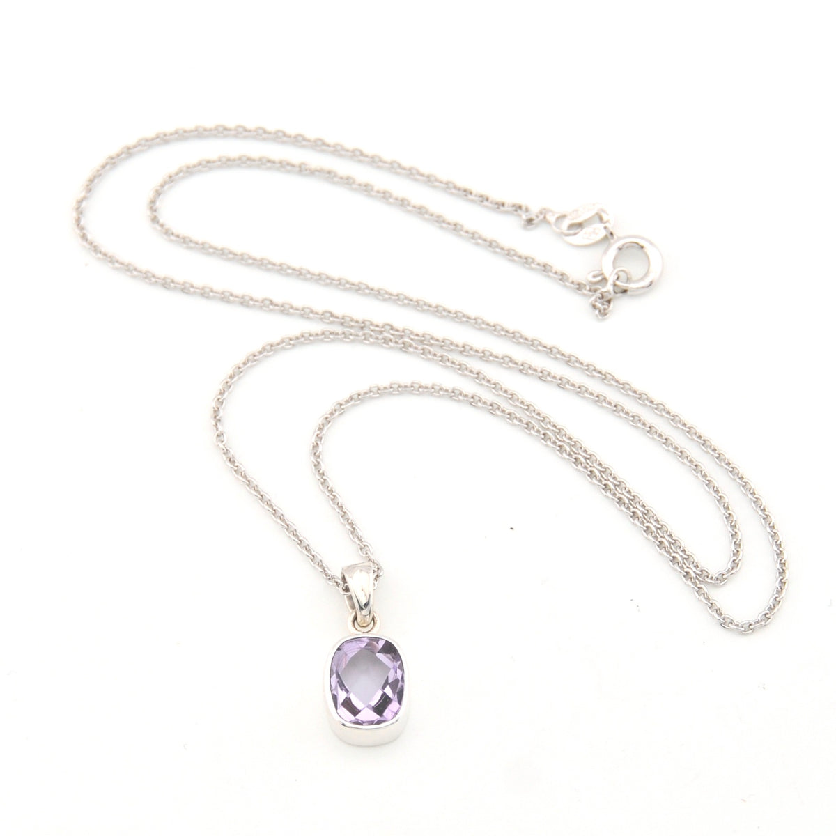 Silver necklace with a purple pendant on a white background