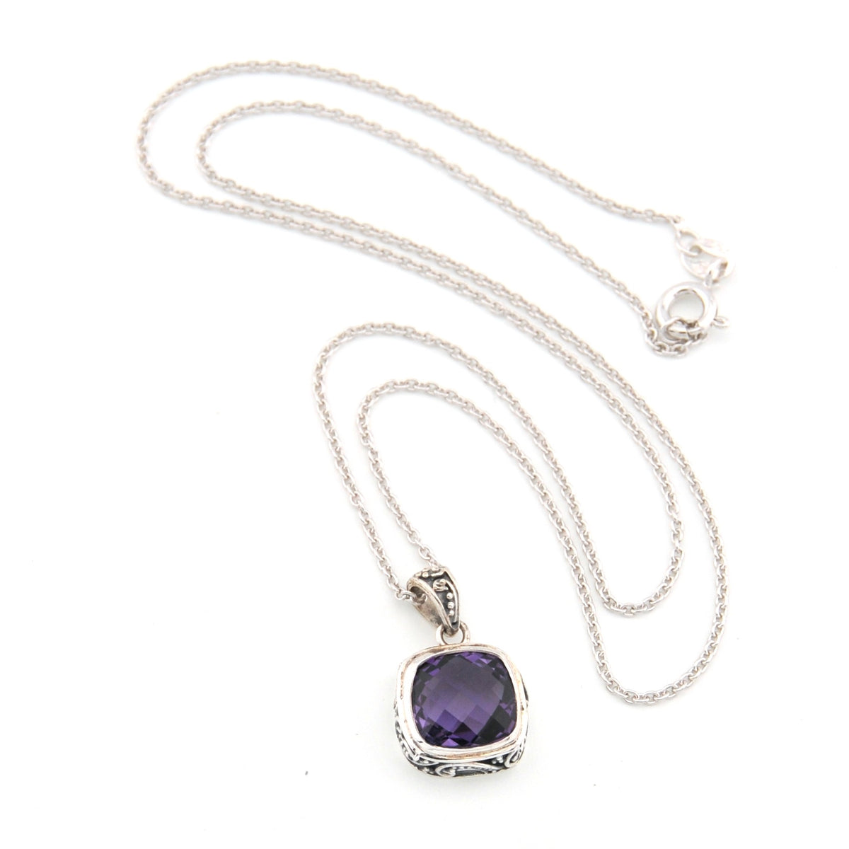 Silver necklace with a purple pendant on a white background