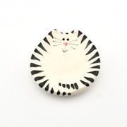 Round ceramic dish with a black and white striped cat design on a white background