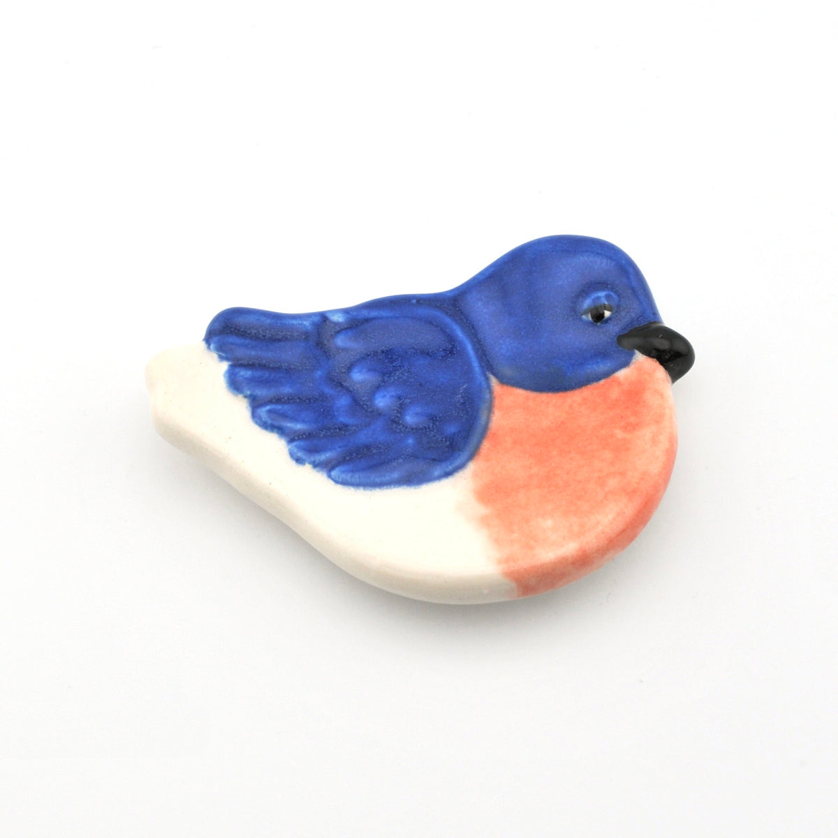 Decorative ceramic bird with blue and pink colors on a white background