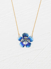 Blue flower-shaped pendant on a gold chain against a white background