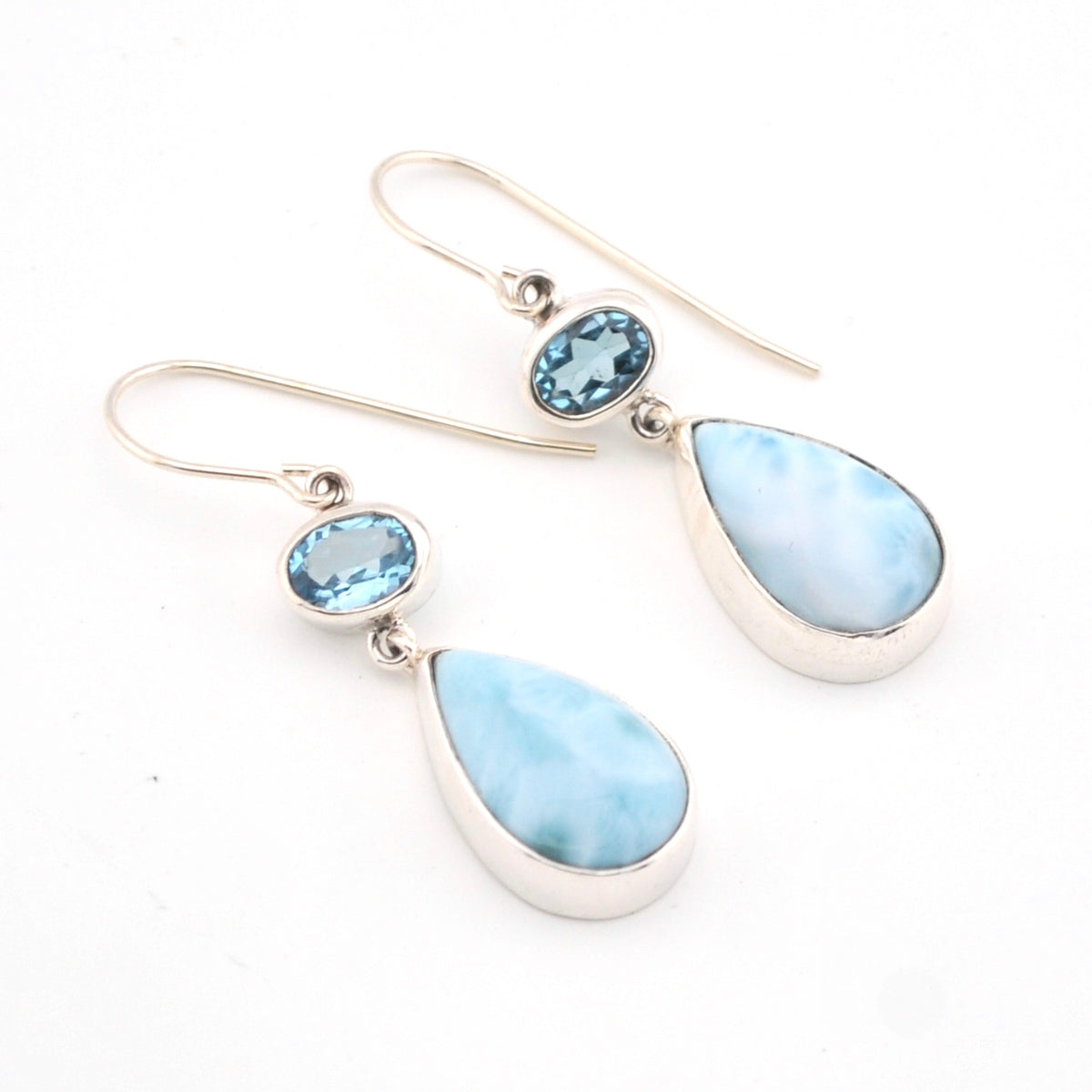 Pair of earrings with blue teardrop stones on a white background