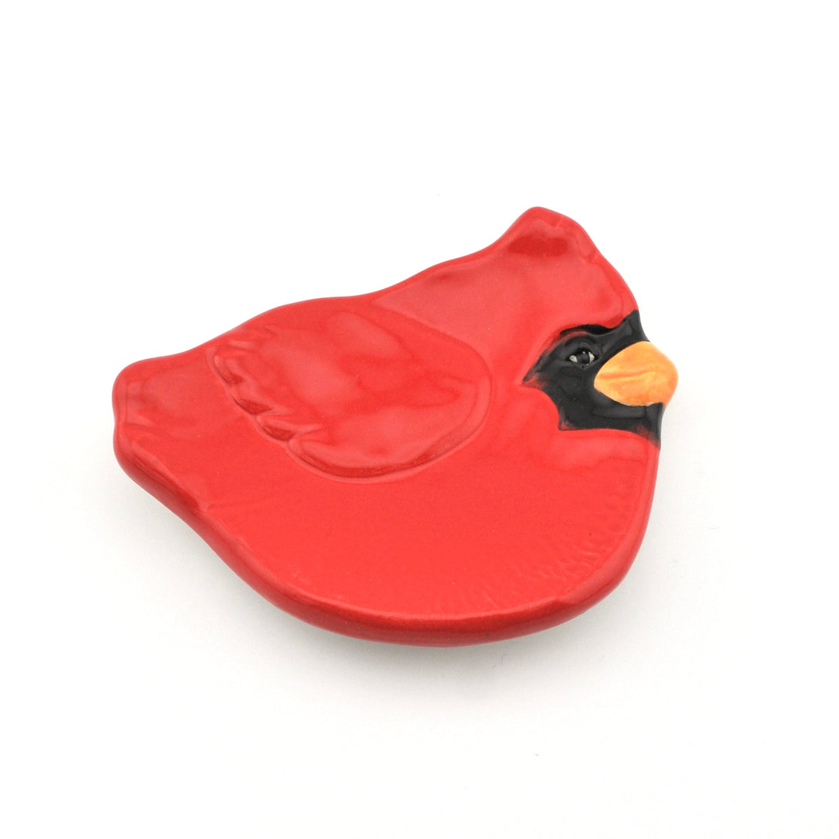 Red bird-shaped object with a yellow beak on a white background