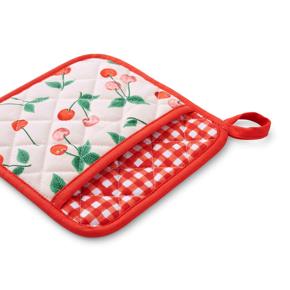 Quilted pot holder with cherry design on a white background