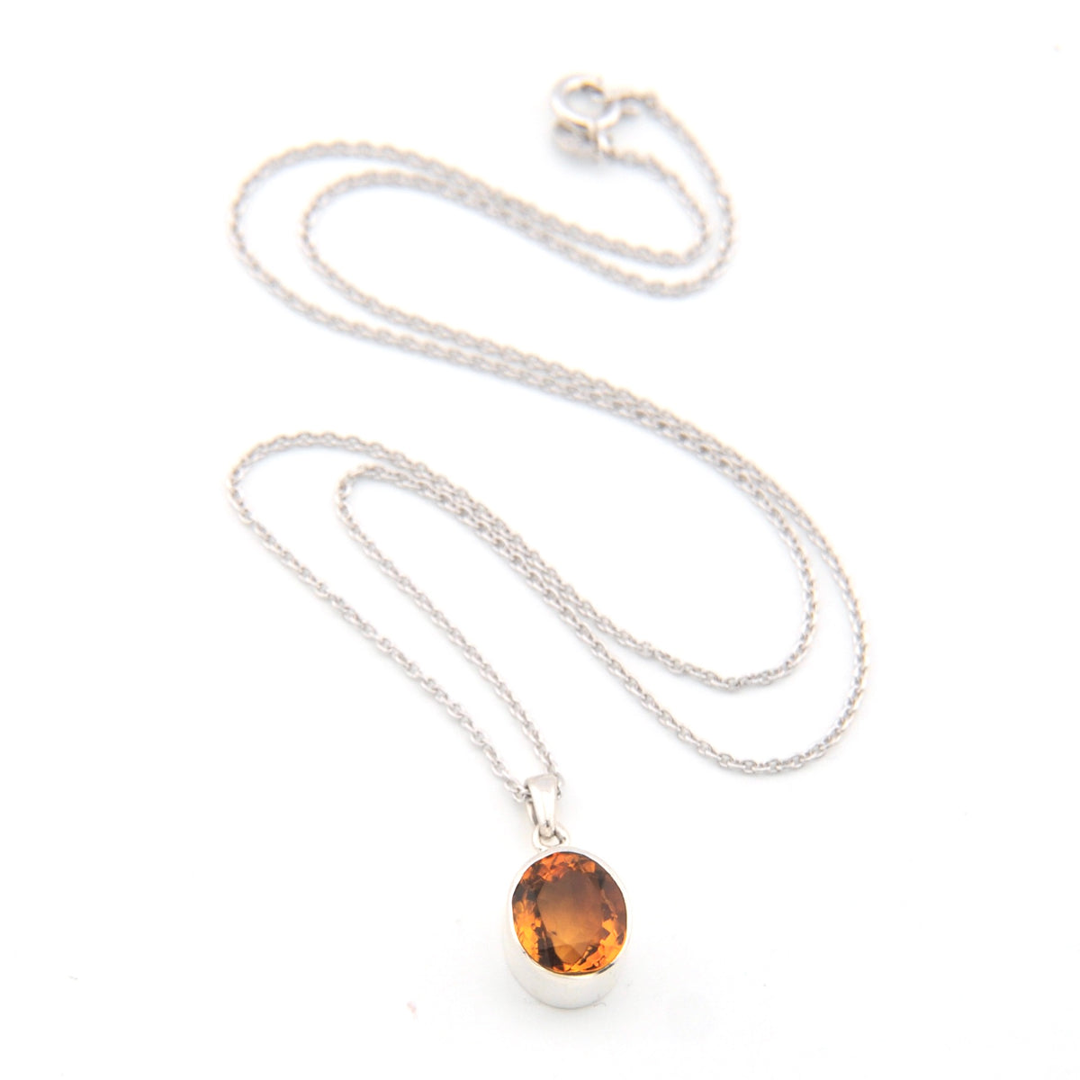 Silver necklace with a round citrine pendant on a white background