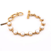 Gold bracelet with pearls on a white background