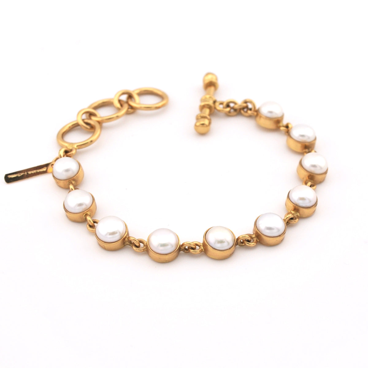 Gold bracelet with pearls on a white background