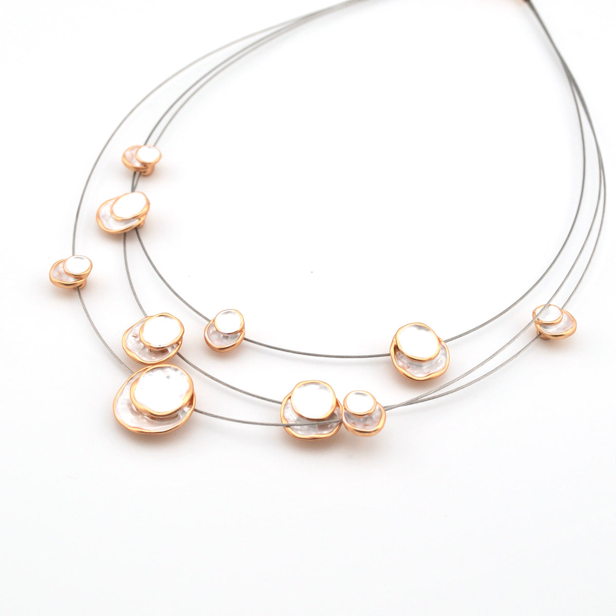 Necklace with gold and pearl-like pendants on a white background