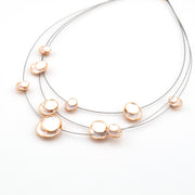 Necklace with gold and pearl-like pendants on a white background