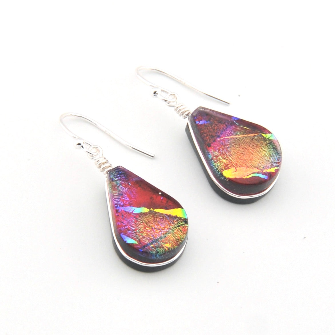 Teardrop-shaped earrings with multicolored iridescent finish on a white background