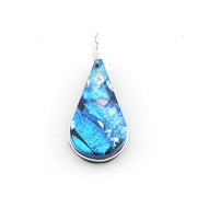 A teardrop-shaped pendant featuring a vibrant blue marbled pattern with silver and black accents, set in a silver-toned bezel with a silver wire-wrapped hook at the top, shown against a plain white background.